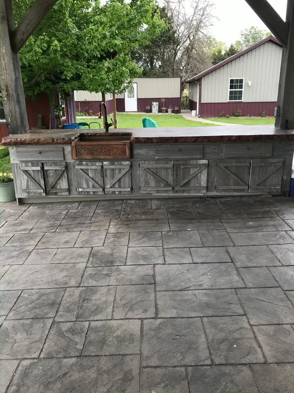 Concrete slab poured for an outdoor kitchen and grill area as part of a backyard outdoor living build