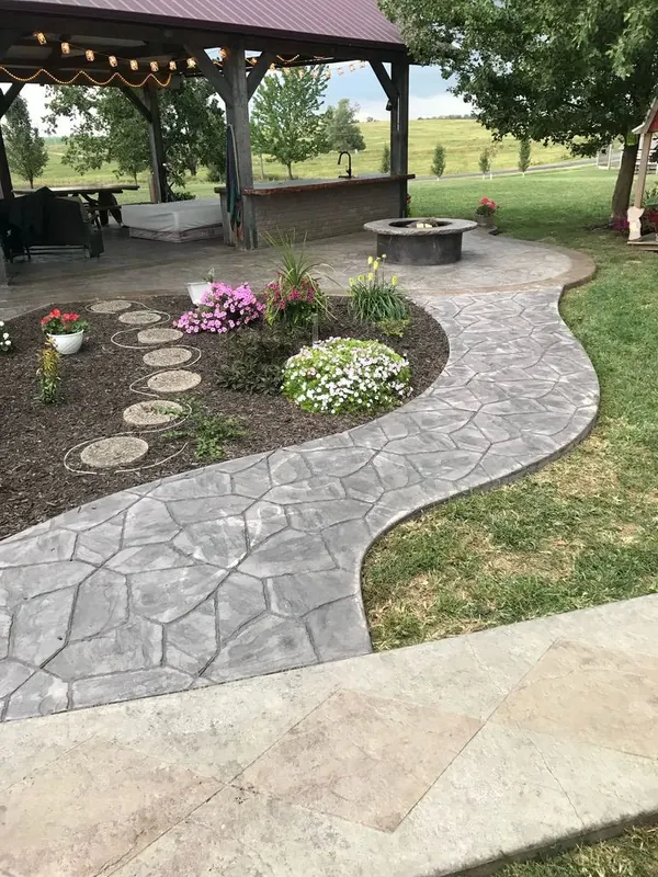 Stamped concrete walkway leading to a covered pavilion, poured with a decorative border and a curved edge